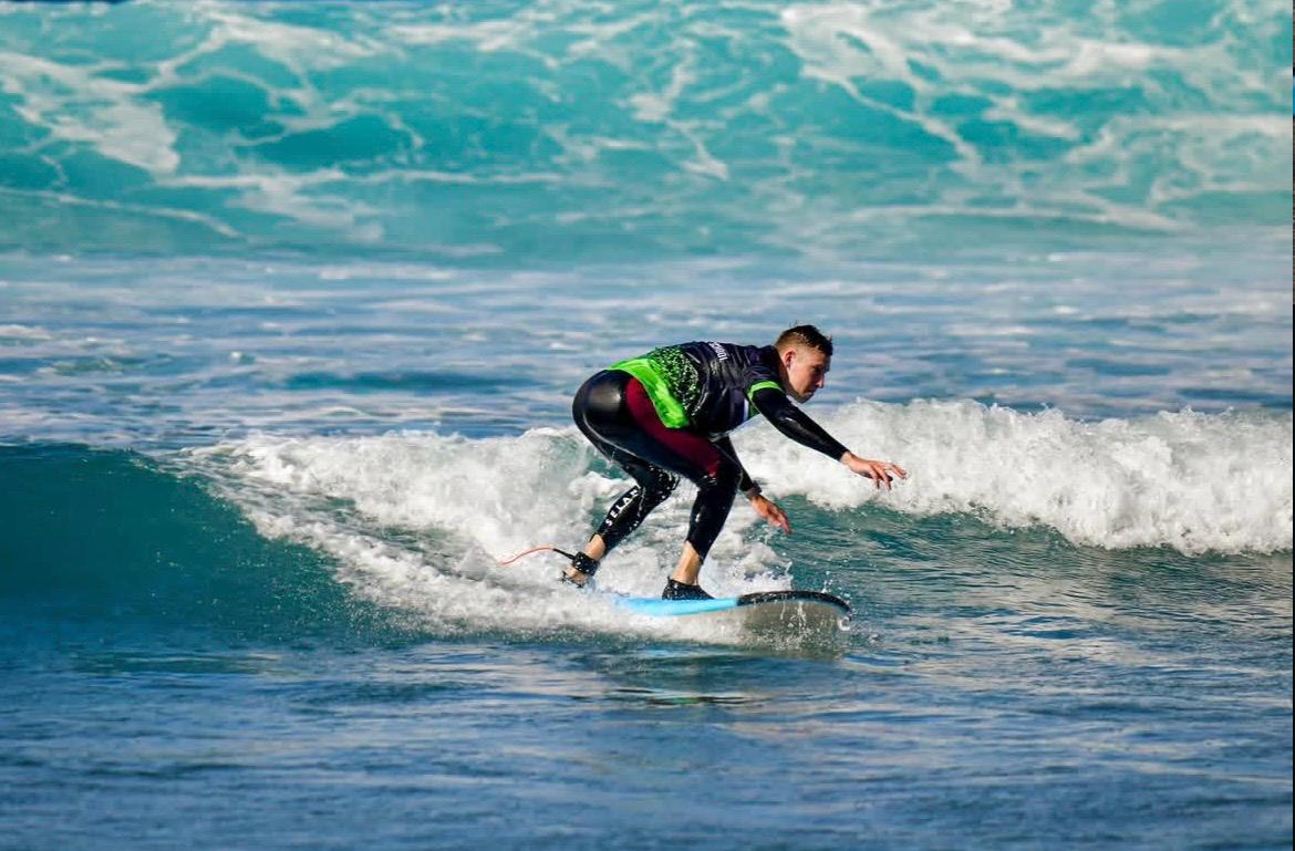 Surfista cogiendo una ola durante una clase de Ika Ika
